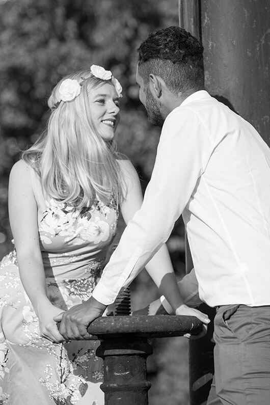 Engagementshooting Fotoshooting vor der Hochzeit auf einem alten Bahnhof. Das Brautpaar schaut sich an