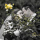 Brautpaar im Garten, versteckt hinter einem Rosenstrauch