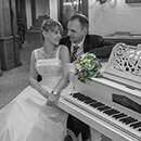 ein Brautpaar am Klavier - schwarz-weiß Hochzeitsbilder