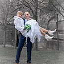 Winterhochzeit -der Bräutigam trägt seine Braut auf dem Arm