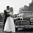 Das Brautpaar mit einem Oldimer - schwarz-weiss-Foto